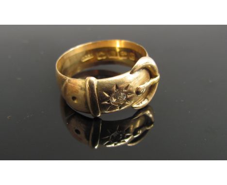 An 18ct gold buckle ring set with single diamond 0.10ct diamond. Size O, 6.7g