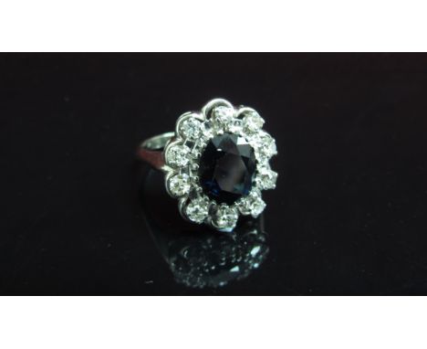 A white gold sapphire and diamond cluster ring, shank stamped 18k. Size R, 6.3g