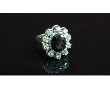 A white gold sapphire and diamond cluster ring, shank stamped 18k. Size R, 6.3g