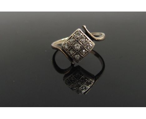 A gold ring set with nine diamonds in crossover setting, marks rubbed. Size I, 1.5g