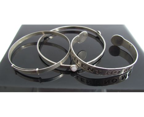 A bangle set with three hardstones, a silver engraved and torque bangle with motto, stamped sterling