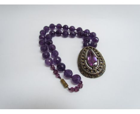 A large amethyst bead necklace hung with pendant/brooch