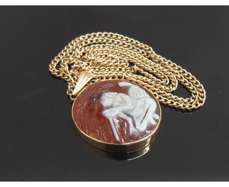 A carved cornelian oval pendant depicting a man with a peace pipe in a 9ct gold mount hung on chain 58cm long