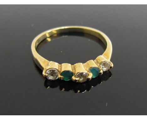 A gold ring set with emerald and clear stones, stamped 18ct. Size N, 2.3g