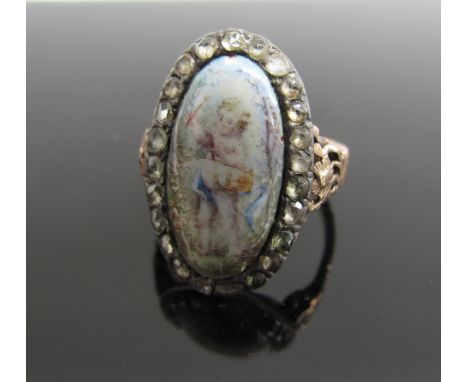 A Georgian dress ring centred by an oval panel of putto within rose-chip border on a later gold coloured shank with pierced s