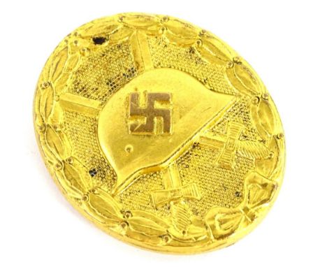 A German Third Reich gilt wound badge, cast to the centre with a German helmet and swastika, within a laurel wreath band, lac