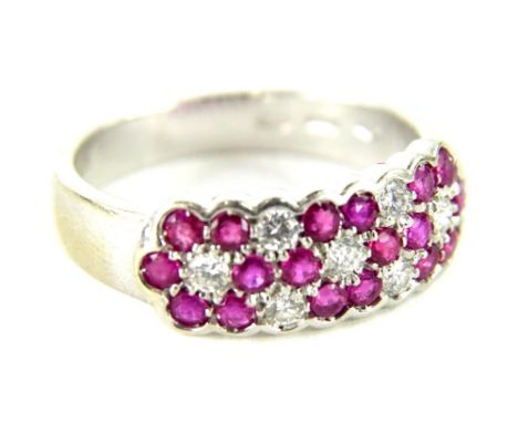 An 18ct gold ruby and diamond dress ring, with design of three cluster groups set with central diamond and surrounded by six 