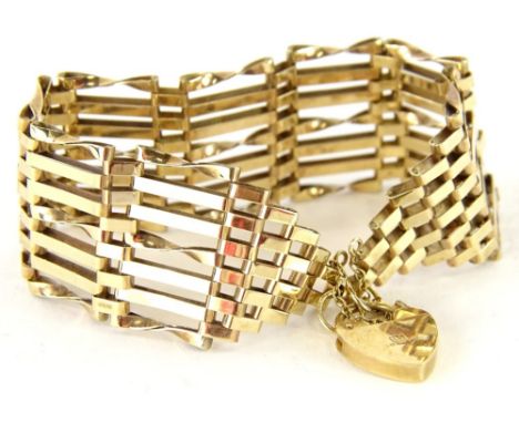 A 9ct gold gate bracelet, with seven bar design, with four straight bars and three twist bars, with safety chain and heart sh