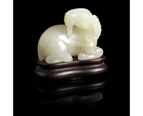 PALE CELADON JADE 'GOAT' CARVING carved in round, the seated goat with its legs tucked underneath its body, its head turns to