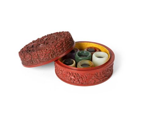 GROUP OF FIVE THUMB RINGS comprising: a translucent purple coloured stone; a bone carved piece; a translucent amber-coloured 