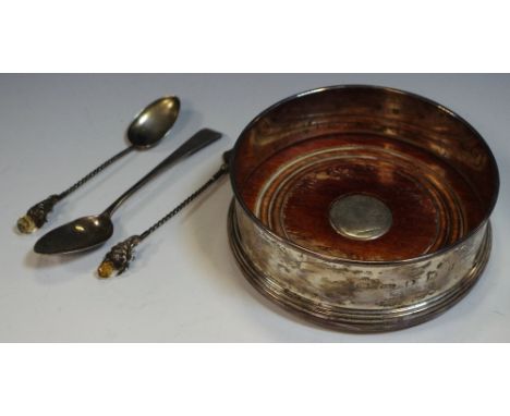 A silver bottle coaster; a silver thistle fork and spoon; a silver tea spoon (4)