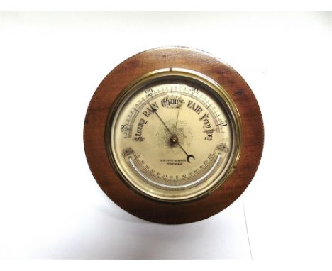 AN EDWARDIAN ANEROID BAROMETER/THERMOMETER  the silvered dial inscribed 'A E COE NORWICH', in circular mahogany case with inl