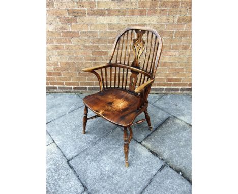 A BOW-BACK WINDSOR ARMCHAIR WITH PIERCED SPLAT BACK  on turned supports with crinoline stretcher base, the dished elm seat 54