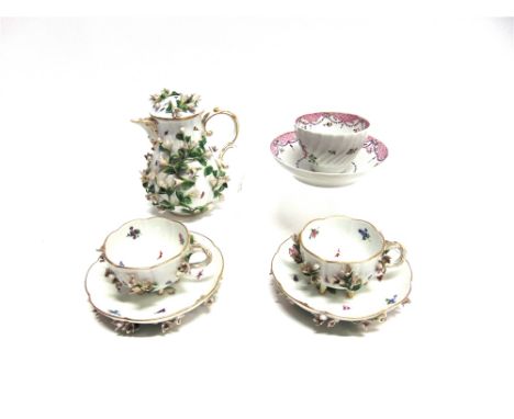 A MEISSEN STYLE FLORAL ENCRUSTED COFFEE POT AND COVER 16cm high, and matching pair of cups and saucers, all with underglaze b