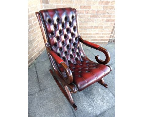 A MODERN MAHOGANY FRAMED ROCKING ARMCHAIR  with red leather button upholstery, 59cm wide 92cm deep 94cm high