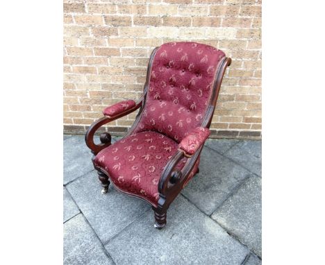 A VICTORIAN CARVED MAHOGANY FRAMED ARMCHAIR  with button upholstered back and serpentine front seat on turned supports, 72cm 