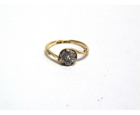 A SEVEN STONE DIAMOND FLOWER HEAD CLUSTER RING stamped '18ct', set with single cuts, finger size J, 2g gross