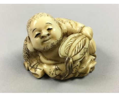 JAPANESE IVORY NETSUKE,Meiji period, modelled as a reclined figure holding a fan, signed, 4cm wide