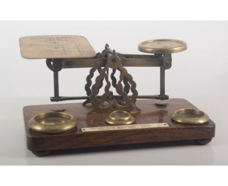 A set of oak and brass postal scales and weights, 23cms.