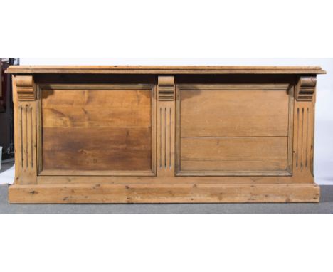 Victorian pine counter, rectangular top with a moulded edge, three panelled sides, one side with a shelf and a bank of drawer