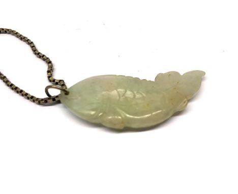 A carved jade fish amulet on a sterling silver chain.