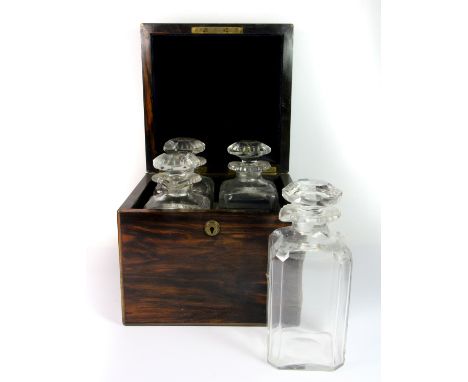 An 18th/ early 19th century coromandel veneered four bottle Tantalus box with original cut glass decanters, 22 x 22 x 23cm.