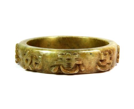 A Chinese carved celadon green jade bangle with relief character decoration, internal Dia. 6.3cm.