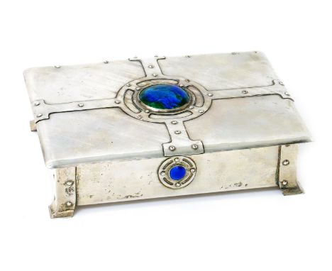 A silvered copper casket and cover probably by A.E. Jones,  the hinged cover cast with strapwork decoration and set with gree