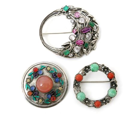 A silver brooch the design attributed to Edith Linnell, wirework foliage cluster set with amethyst, emeralds and other stones