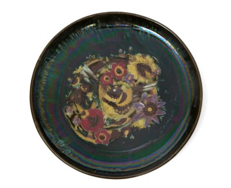 A Linthorpe Pottery plate designed by Dr Christopher Dresser, impressed with a bird before stylised flowers in colours with a