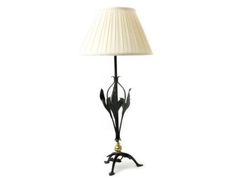 A W.A.S Benson wrought iron table lamp,  on arched tripod foot with foliate panels  the central stem flanked with flaring fol