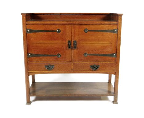 A J.A.S Shoolbred oak sideboard, twin hinged cupboard with internal shelf, above drawers,  patinated metal furniture, stamped