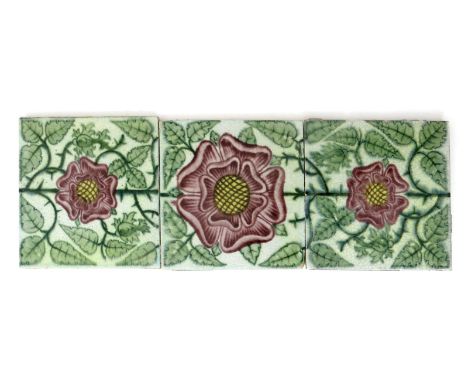 A William De Morgan Sands End pottery three tile panel, painted with a Tudor Rose repeat, in shades of green, aubergine and y