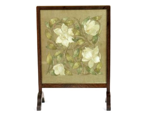 A Liberty & Co oak firescreen with embroidered panel,  the rectangular panel embroidered with flowers in scrolling foliage in