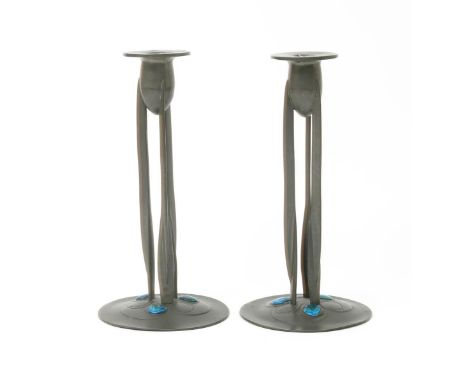 A pair of Liberty & Co  Tudric Pewter and enamel candlesticks designed by Archibald Knox, model no.0223, the shallow domed ba