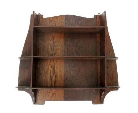 A Liberty & Co oak shelf unit,  three shelves on shaped back and curved corner shelves, applied ivorine label, 77cm. wide.