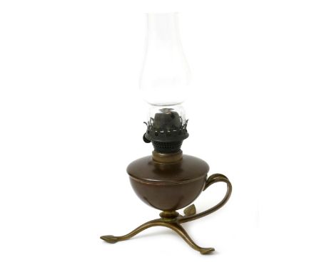 A W.A.S. Benson copper and brass oil lamp, the copper reservoir on tripod foot with foliate feet and curved handle, with glas