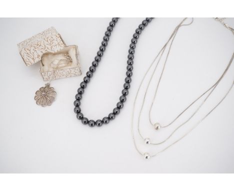 A contemporary white metal triple-stand necklace strung with three spherical baubles, a vintage white-metal filigree necklace