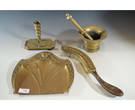 A brass pestle and mortar, crumb tray and brush, and candlestick