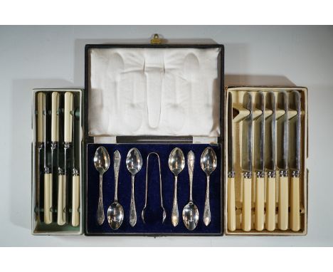 A late Victorian / Edwardian cased set of electroplate tea spoons and sugar tongs, and two boxed sets of ivorine handled kniv