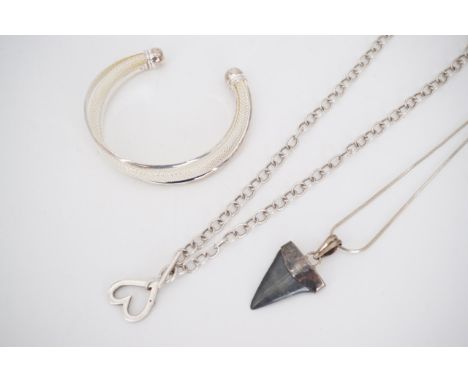 A contemporary white metal pendant on chain, of heart-shape, set with a pink cubic zirconia, stamped '925', a contemporary wh