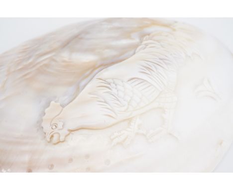 A pearl oyster shell polished and carved in depiction of a cockerel, 15 cm x 11 cm