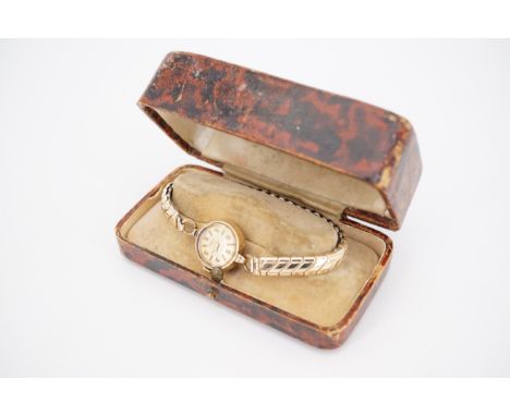 A lady's 9ct gold cased Smiths wristlet watch, having Roman and Arabic numerals, on a rolled-gold flexible bracelet strap, an