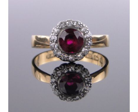 A 22ct ruby and diamond cluster ring, ruby 6mm diameter, setting 11mm across, size R.