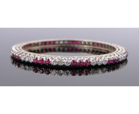 An Indian unmarked gold diamond and synthetic ruby set slave bangle, total diamond content approx. 3cts, 70mm across.