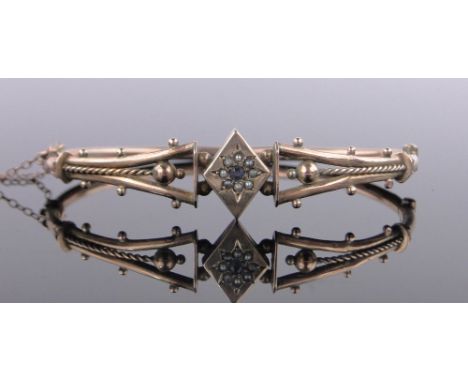 A Victorian 9ct gold hinged bangle,with central cluster of sapphire and pearls, 5.5g.