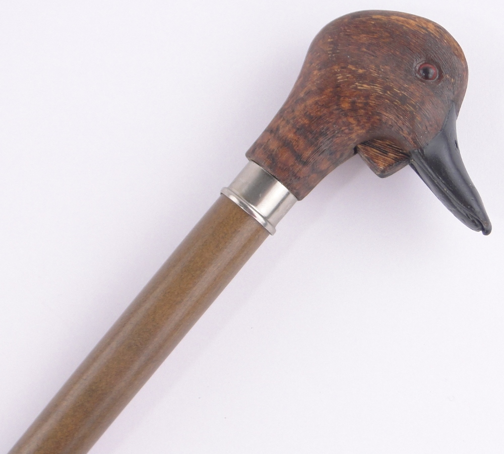 A carved and stained wood duck's head design walking stick, with ...