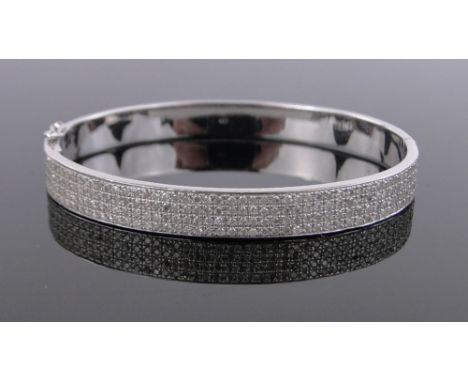 An 18ct white gold diamond encrusted hinged bangle,total diamond content approx. 5cts, 28.5g.
