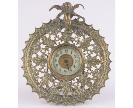 An ornate 19th century cast and pierced brass cased mantel clock, surmounted by a cherub, by the British United Clock Company