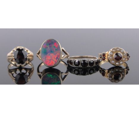 A 9ct gold opal set ring, opal length 17mm and 3 9ct gold garnet set rings, (4).